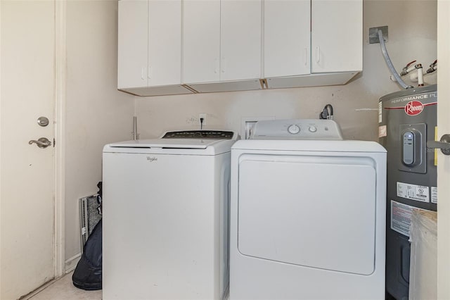 washroom with water heater, washing machine and dryer, and cabinets