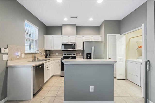 kitchen with sink, white cabinetry, a center island, light tile patterned floors, and appliances with stainless steel finishes