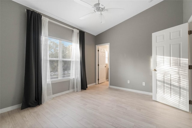 spare room featuring ceiling fan, lofted ceiling, and light wood-type flooring