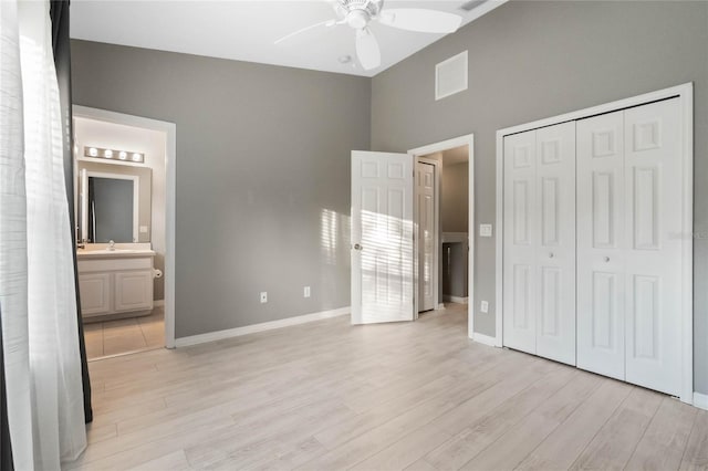 unfurnished bedroom with connected bathroom, a closet, ceiling fan, and light wood-type flooring