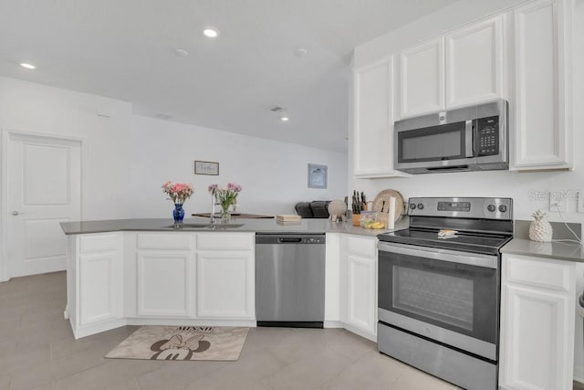 kitchen featuring sink, light tile patterned floors, appliances with stainless steel finishes, white cabinets, and kitchen peninsula