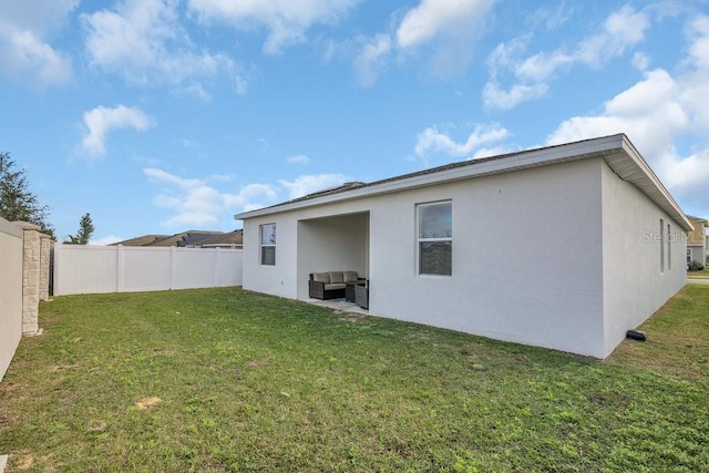 rear view of house featuring a yard