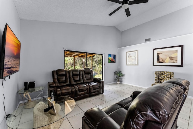 living room featuring ceiling fan, lofted ceiling, light tile patterned floors, and a textured ceiling