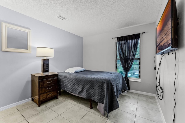 bedroom featuring light tile patterned floors and a textured ceiling