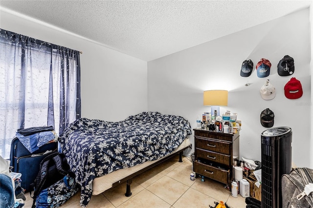 bedroom featuring light tile patterned flooring and a textured ceiling