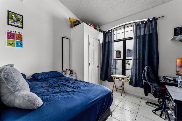 bedroom featuring light tile patterned floors, a closet, and a textured ceiling