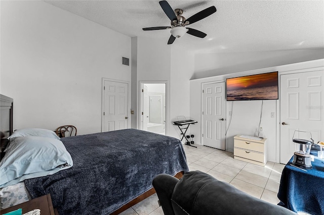 tiled bedroom featuring ceiling fan, vaulted ceiling, and a textured ceiling