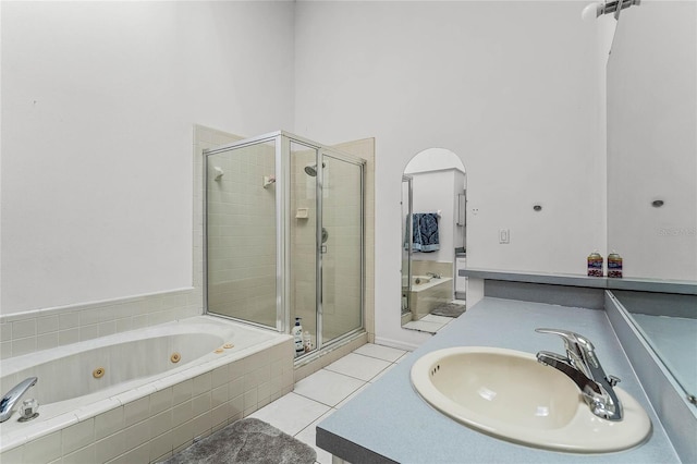 bathroom featuring tile patterned flooring, separate shower and tub, and sink