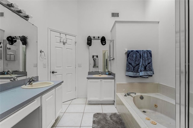 bathroom with vanity, tiled tub, and tile patterned flooring