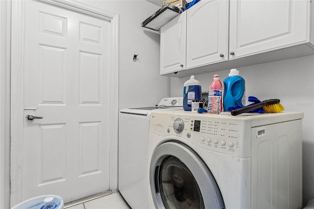 clothes washing area featuring independent washer and dryer, cabinets, and light tile patterned flooring