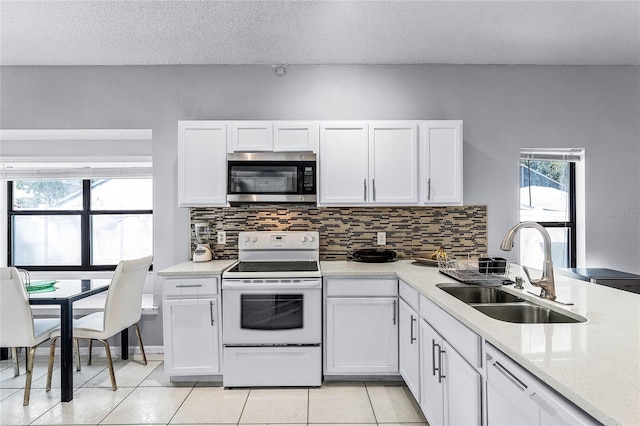 kitchen featuring white cabinetry, sink, light tile patterned floors, and electric range