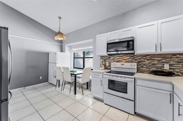 kitchen with stainless steel appliances, tasteful backsplash, hanging light fixtures, and white cabinets