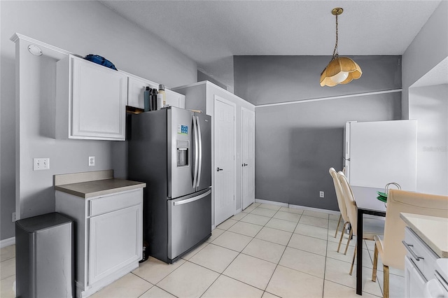 kitchen featuring stainless steel refrigerator with ice dispenser, white cabinetry, and hanging light fixtures