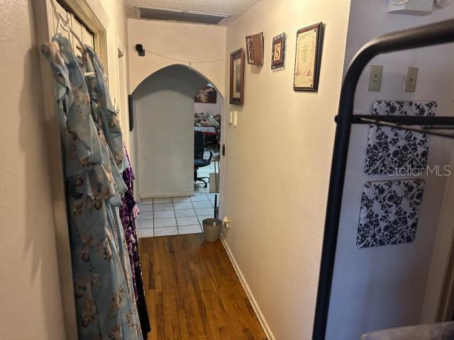 hallway with dark hardwood / wood-style floors and a textured ceiling