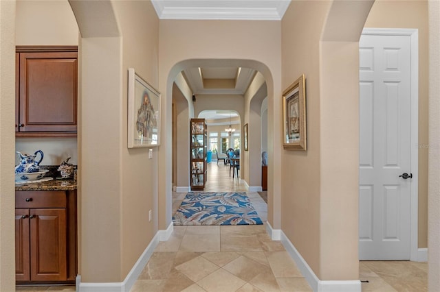 hallway with crown molding and a notable chandelier