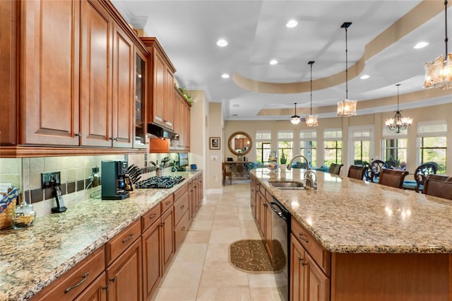 kitchen with sink, a spacious island, black appliances, a kitchen bar, and decorative light fixtures