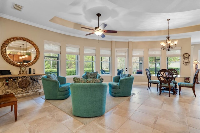 tiled living room with ornamental molding, plenty of natural light, a tray ceiling, and ceiling fan with notable chandelier