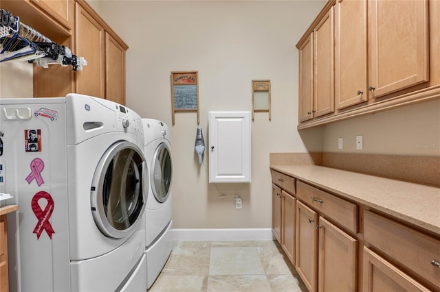 clothes washing area featuring cabinets and washer and dryer