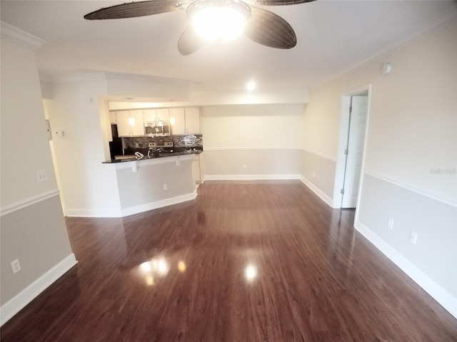 unfurnished living room featuring ornamental molding, dark wood-type flooring, and ceiling fan