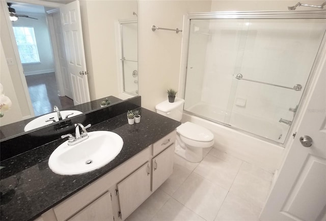 full bathroom featuring toilet, tile patterned floors, bath / shower combo with glass door, and vanity