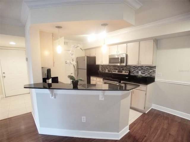 kitchen featuring white cabinetry, ornamental molding, appliances with stainless steel finishes, and decorative light fixtures