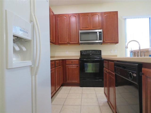 kitchen featuring sink, light tile patterned floors, and black appliances