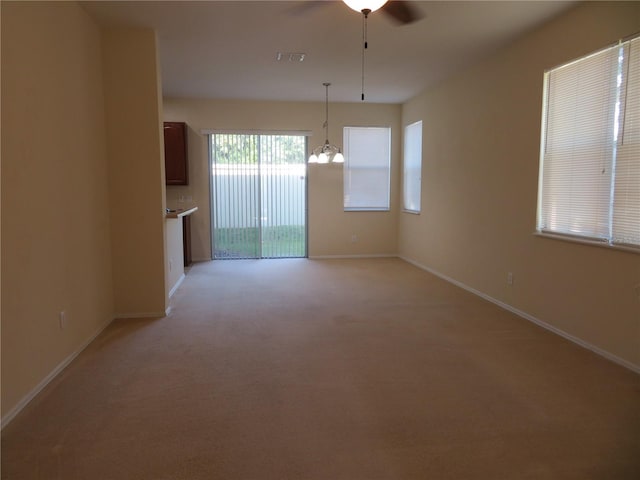 interior space featuring ceiling fan with notable chandelier