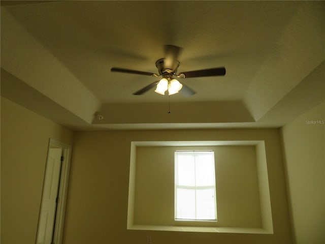 unfurnished room with a raised ceiling and ceiling fan