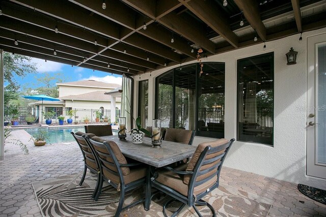 view of patio featuring a fenced in pool, outdoor dining space, and fence