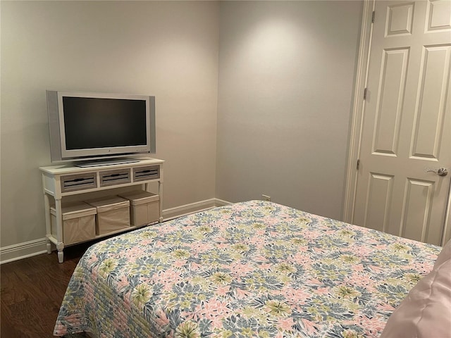 bedroom featuring dark wood finished floors and baseboards