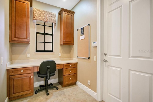 office area with built in study area and baseboards