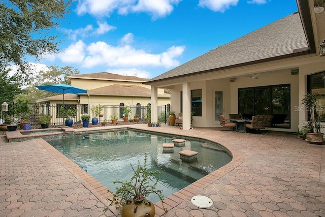 view of swimming pool featuring a patio, a pool with connected hot tub, fence, and a ceiling fan