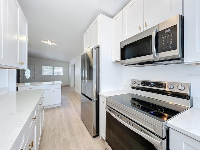 kitchen featuring light hardwood / wood-style flooring, light stone countertops, white cabinets, and appliances with stainless steel finishes