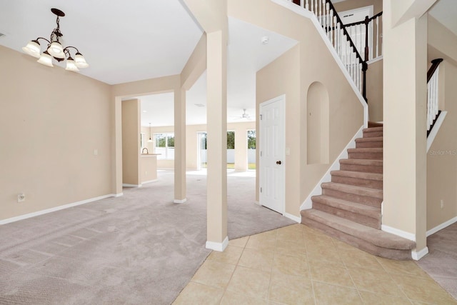 carpeted foyer with an inviting chandelier