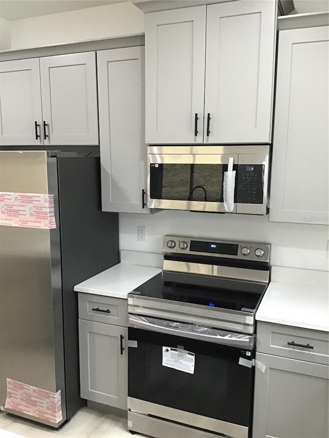 kitchen featuring stainless steel appliances and gray cabinets