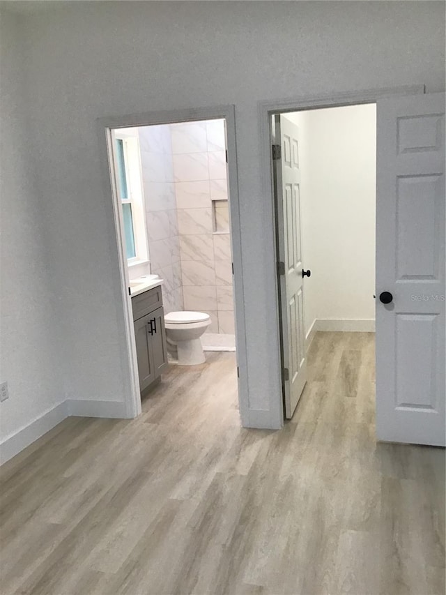 bathroom with wood-type flooring, toilet, and vanity