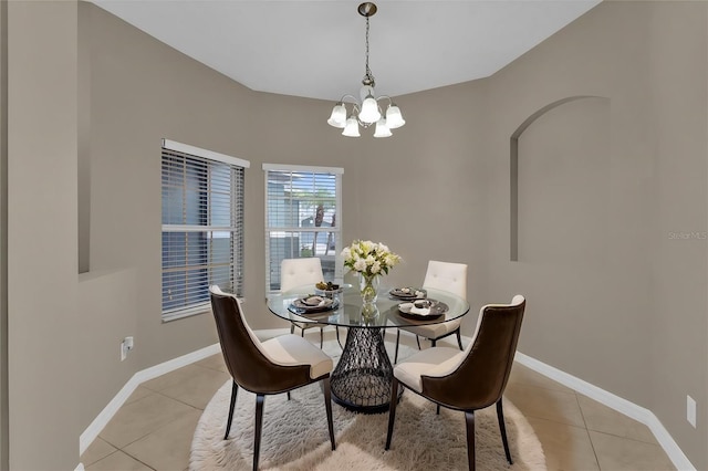 dining space featuring light tile patterned flooring and a notable chandelier