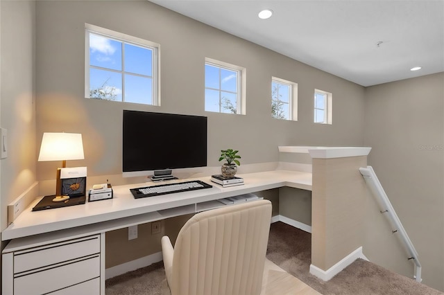 office with built in desk and light colored carpet