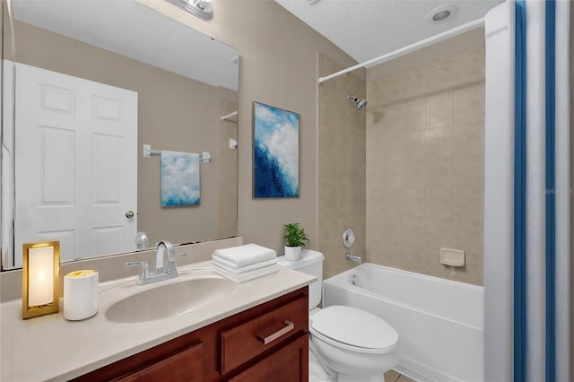 full bathroom featuring vanity, tiled shower / bath combo, and toilet