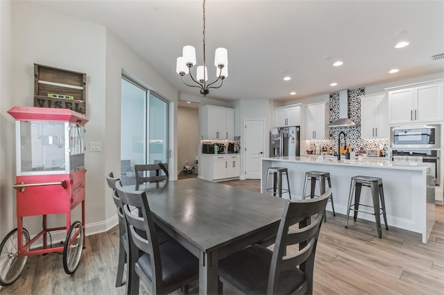 dining area featuring light hardwood / wood-style flooring and a chandelier