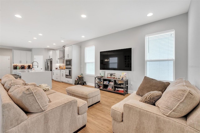 living room featuring sink and light hardwood / wood-style floors