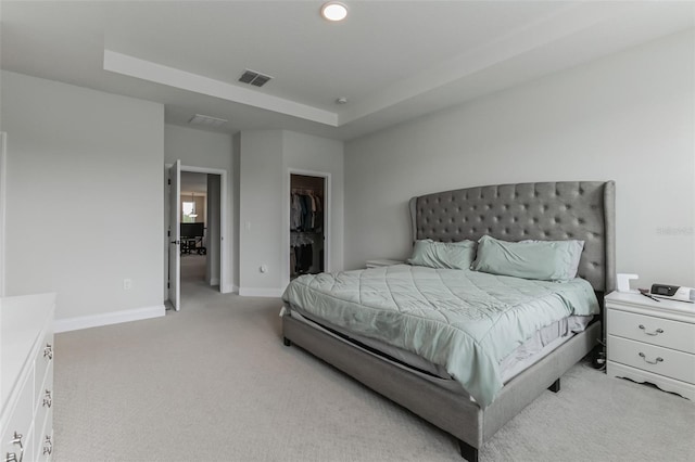 carpeted bedroom featuring a walk in closet and a closet