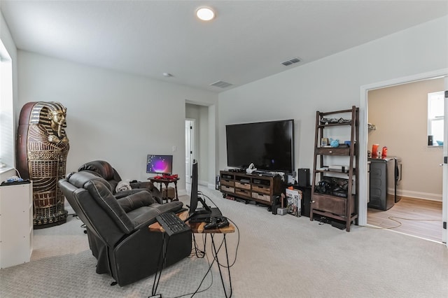 living room featuring independent washer and dryer and light colored carpet