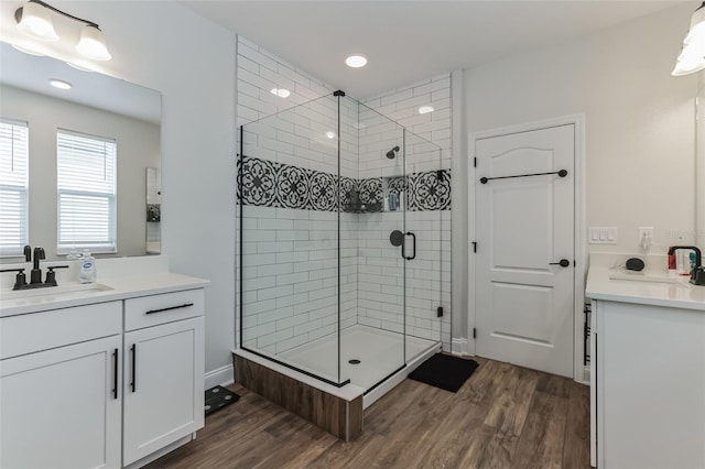 bathroom with vanity, wood-type flooring, and a shower with door