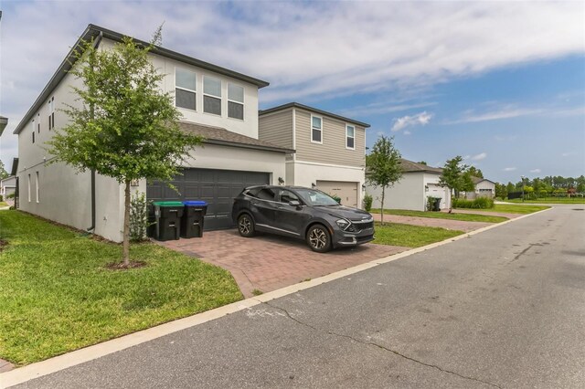 view of front of house featuring a garage and a front lawn