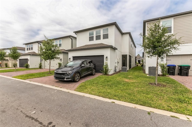 view of front property featuring cooling unit, a garage, and a front yard