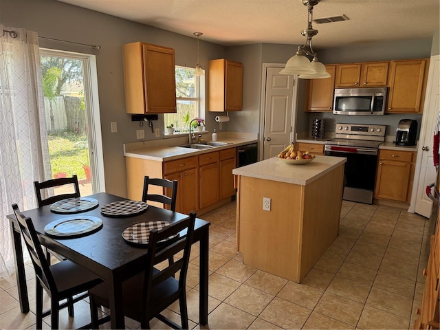 kitchen with sink, decorative light fixtures, a center island, and appliances with stainless steel finishes