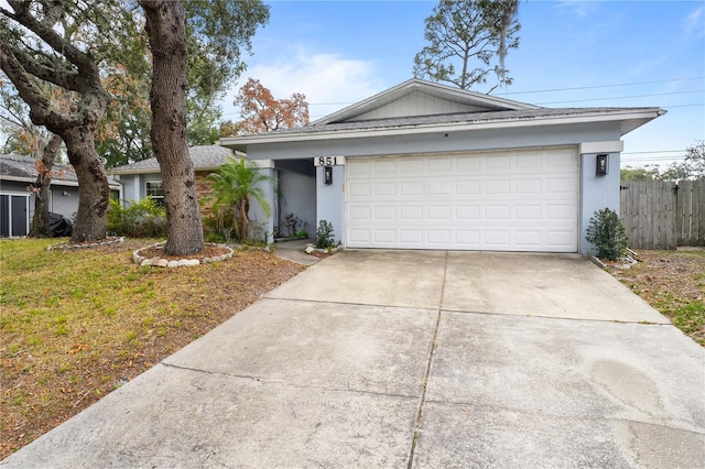 single story home with a garage and a front lawn