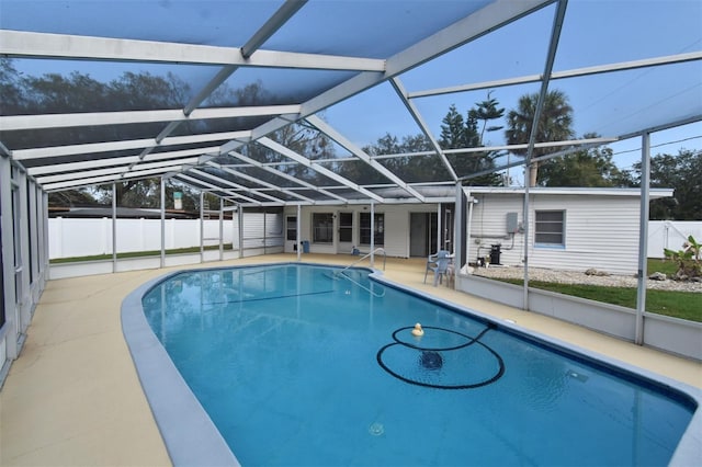 view of pool with a patio area and glass enclosure