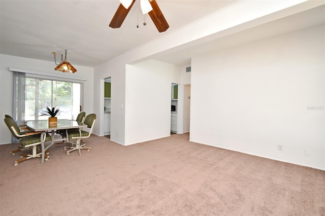 carpeted dining area with ceiling fan